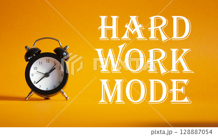 Hard Work Mode symbol. Concept word Hard Work Mode on Beautiful orange background with alarm clock. Business and Hard Work Mode concept. Copy space 128887054