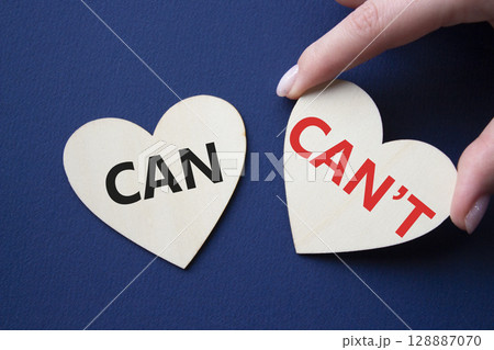 Can or Cant symbol. Concept word Can or Cant on wooden hearts. Businessman hand. Beautiful deep blue background. Business and Can or Cant concept. Copy space 128887070