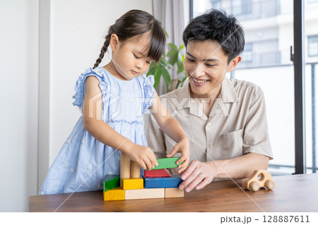 積み木で遊ぶパパと娘の笑顔あふれる時間 128887611