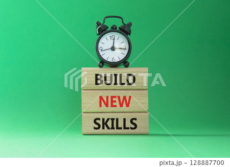 Build New skills symbol. Concept word Build New skills on wooden blocks with alarm clock. Beautiful green background. Business and Build New skills concept. Copy space Build New skills symbol. Concept word Build New skills on wooden blocks with alarm clock. Beautiful green background. Business and Build New skills concept. Copy space 128887700