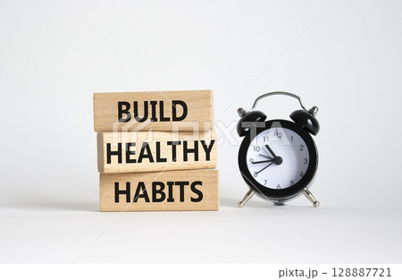 Healthy habits symbol. Concept word Build Healthy habits on wooden blocks with alarm clock. Beautiful white background. Healthy lifestyle and Healthy habits concept. Copy space Healthy habits symbol. Concept word Build Healthy habits on wooden blocks with alarm clock. Beautiful white background. Healthy lifestyle and Healthy habits concept. Copy space 128887721
