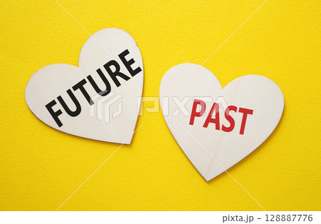 Future or Past symbol. Concept word Future or Past on wooden hearts. Beautiful yellow background. Business and Future or Past concept. Copy space Future or Past symbol. Concept word Future or Past on wooden hearts. Beautiful yellow background. Business and Future or Past concept. Copy space 128887776