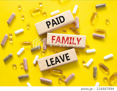 Paid Family Leave symbol. Concept words Paid Family Leave on wooden blocks. Beautiful yellow background with pills. Healthcare and Paid Family Leave concept. Copy space. 128887894