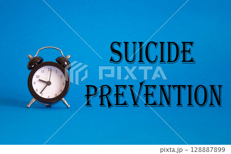 Suicide Prevention symbol. Concept words Suicide Prevention on Beautiful blue background with alarm clock. Medicine and Suicide Prevention concept. Copy space. 128887899