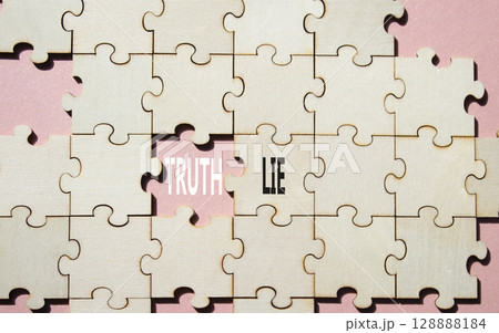Truth or Lie symbol. Concept word Truth or Lie on wooden puzzle. Beautiful pink background. Business and Truth or Lie concept. Copy space 128888184