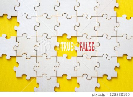 True or False symbol. Concept word True or False on wooden puzzle. Beautiful yellow background. Business and True or False concept. Copy space 128888190
