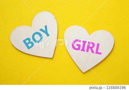 Boy or Girl symbol. Concept word Boy or Girl on wooden hearts. Beautiful yellow background. Gender and Boy or Girl concept. Copy space Boy or Girl symbol. Concept word Boy or Girl on wooden hearts. Beautiful yellow background. Gender and Boy or Girl concept. Copy space 128888196