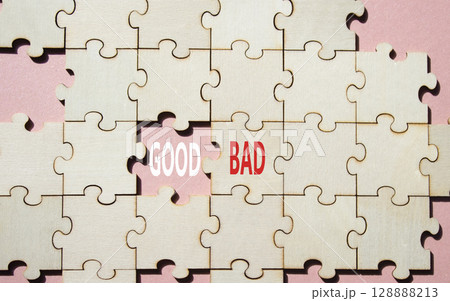 Good or Bad symbol. Concept word Good or Bad on wooden puzzle. Beautiful pink background. Business and Good or Bad concept. Copy space 128888213