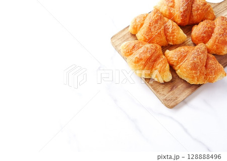 クロワッサン - 焼き立てのクロワッサンがサービングボードにのせられた朝の風景 クロワッサン - 焼き立てのクロワッサンがサービングボードにのせられた朝の風景 128888496
