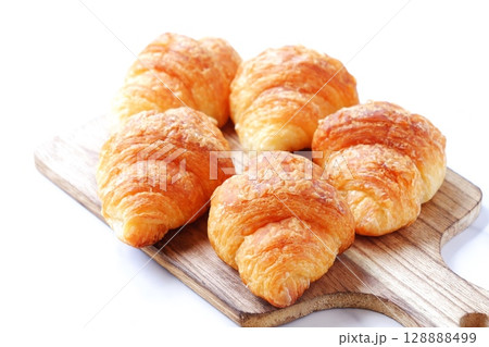 クロワッサン - 焼き立てのクロワッサンがサービングボードにのせられた朝の風景 128888499