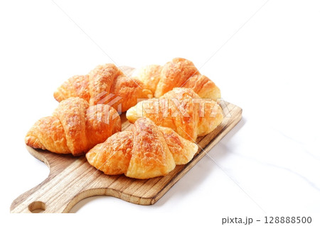 クロワッサン - 焼き立てのクロワッサンがサービングボードにのせられた朝の風景 128888500