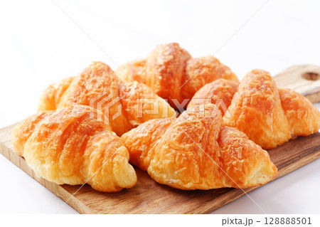 クロワッサン - 焼き立てのクロワッサンがサービングボードにのせられた朝の風景 128888501