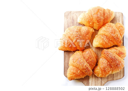 クロワッサン - 焼き立てのクロワッサンがサービングボードにのせられた朝の風景 128888502