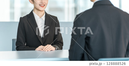 男性客と商談・接客・打ち合わせする若いアジア人ビジネスウーマン 128888526