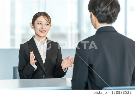 男性客と商談・接客・打ち合わせする若いアジア人ビジネスウーマン 男性客と商談・接客・打ち合わせする若いアジア人ビジネスウーマン 128888528