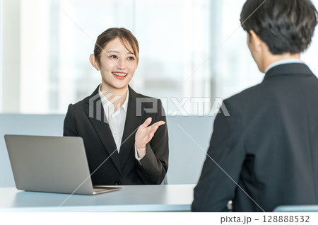 男性客と商談・接客・打ち合わせする若いアジア人ビジネスウーマン 128888532