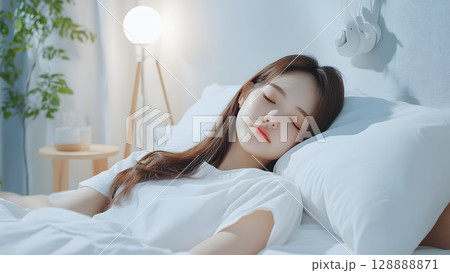 モダンな寝室で静かに眠る若い女性の横顔 モダンな寝室で静かに眠る若い女性の横顔 128888871