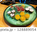 お皿に並べられたカラフルなデザート 128889054