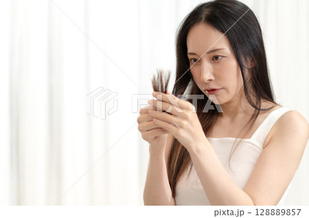 毛先を気にするロングヘアの女性 128889857