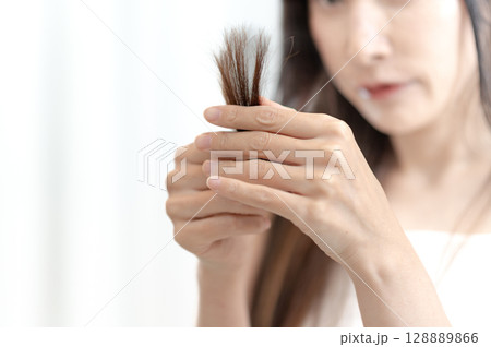 毛先を気にするロングヘアの女性 毛先を気にするロングヘアの女性 128889866