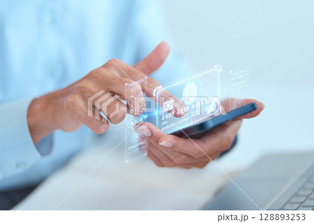 Person Using Smartphone With Holographic Credit Card Display for Digital Payments 128893253