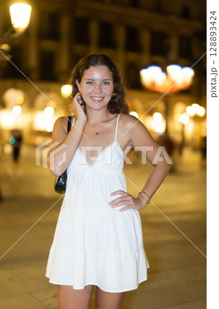 young woman walks along an evening street in Barcelona young woman walks along an evening street in Barcelona 128893424