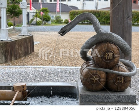 神社の手水舎に置かれたへび 神社の手水舎に置かれたへび 128894056