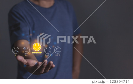 Review Customer, Young Man hand holding emoji five star to review and give 5 stars Review Customer, Young Man hand holding emoji five star to review and give 5 stars 128894714