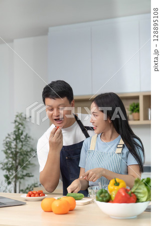 Couple Enjoying Healthy Cooking: Preparing Fresh Ingredients in Kitchen Couple Enjoying Healthy Cooking: Preparing Fresh Ingredients in Kitchen 128895108