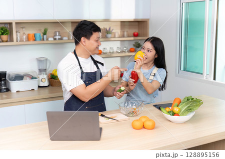 Cooking Fun: Couple Enjoying Healthy Ingredients in Modern Kitchen Cooking Fun: Couple Enjoying Healthy Ingredients in Modern Kitchen 128895156