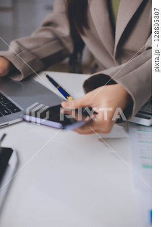 Portrait of young Hispanic professional business woman standing in office. Happy female company executive, smiling businesswoman entrepreneur corporate leader manager looking at camera using tablet 128895807