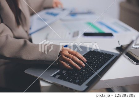 Portrait of young Hispanic professional business woman standing in office. Happy female company executive, smiling businesswoman entrepreneur corporate leader manager looking at camera using tablet Portrait of young Hispanic professional business woman standing in office. Happy female company executive, smiling businesswoman entrepreneur corporate leader manager looking at camera using tablet 128895808