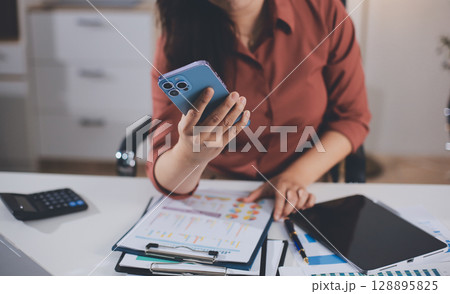 Closeup image of a businesswoman using mobile phone in office Closeup image of a businesswoman using mobile phone in office 128895825