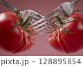 Two forks clashing with ripe tomatoes, creating dramatic and playful scene 128895854