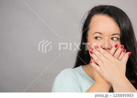 Shocked woman covering her mouth with hand Shocked woman covering her mouth with hand 128895983