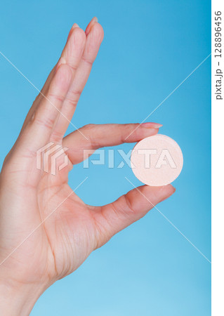 Woman hand holding big effervescent pill 128896456