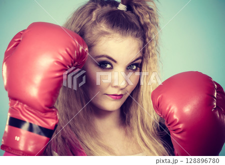 Cute girl in red gloves playing sports boxing 128896780