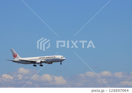 夏空を背景に飛ぶ旅客機 夏の空の旅 着陸するJAL機 夏空を背景に飛ぶ旅客機 夏の空の旅 着陸するJAL機 128897064