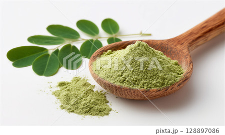 モリンガの粉末と葉が木製スプーンに盛られたシンプルな構図 128897086