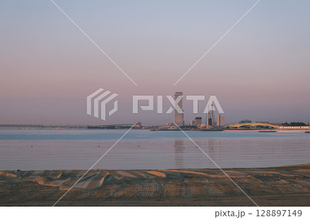 [タルイサザンビーチ]優しい夕日の光に包まれた海辺の風景 128897149