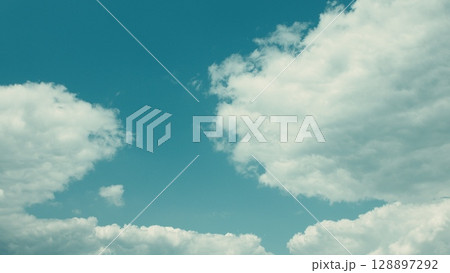 Experience the breathtaking beauty of a cloudy sky with a vibrant blue background 128897292