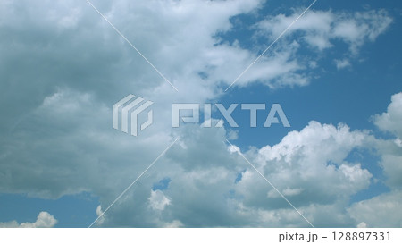 The dynamic and everchanging cloudy skies gracefully hover over a beautiful blue background The dynamic and everchanging cloudy skies gracefully hover over a beautiful blue background 128897331