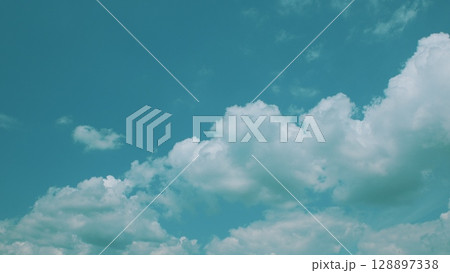 The breathtaking view of a beautifully cloudy sky set against a rich and vibrant blue background 128897338