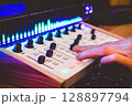 close up producer, sound engineer hand on audio mixing console, control surface. music production, recording, broadcasting concept 128897794