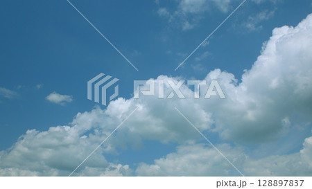 A Beautiful and Expansive Blue Sky Adorned with Fluffy Clouds Floating Gracefully A Beautiful and Expansive Blue Sky Adorned with Fluffy Clouds Floating Gracefully 128897837