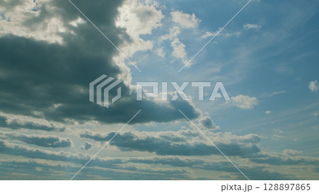 The Beautiful Cloudy Sky featuring Radiant Sunlight passing through Fluffy Clouds The Beautiful Cloudy Sky featuring Radiant Sunlight passing through Fluffy Clouds 128897865