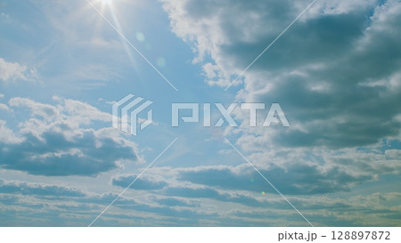 A Beautiful Sky Filled with Fluffy Clouds and Warm Sunlight Glistening Through Them A Beautiful Sky Filled with Fluffy Clouds and Warm Sunlight Glistening Through Them 128897872