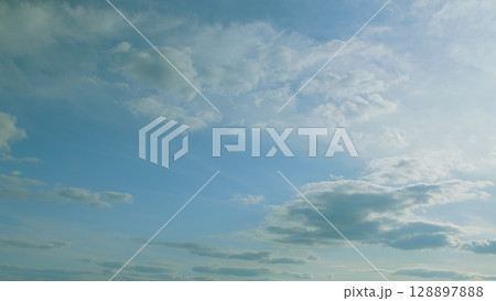 Cumulus Clouds are Suspended Gracefully Above a Beautifully Serene and Calm Blue Sky 128897888