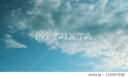 A Beautiful, Serene Blue Sky with Fluffy White Clouds Gracefully Floating Above in Calm Harmony 128897896