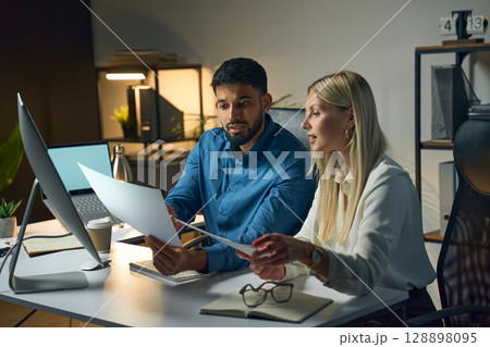 Two Colleagues Working Together in a Modern Office on a Project Document Review Two Colleagues Working Together in a Modern Office on a Project Document Review 128898095